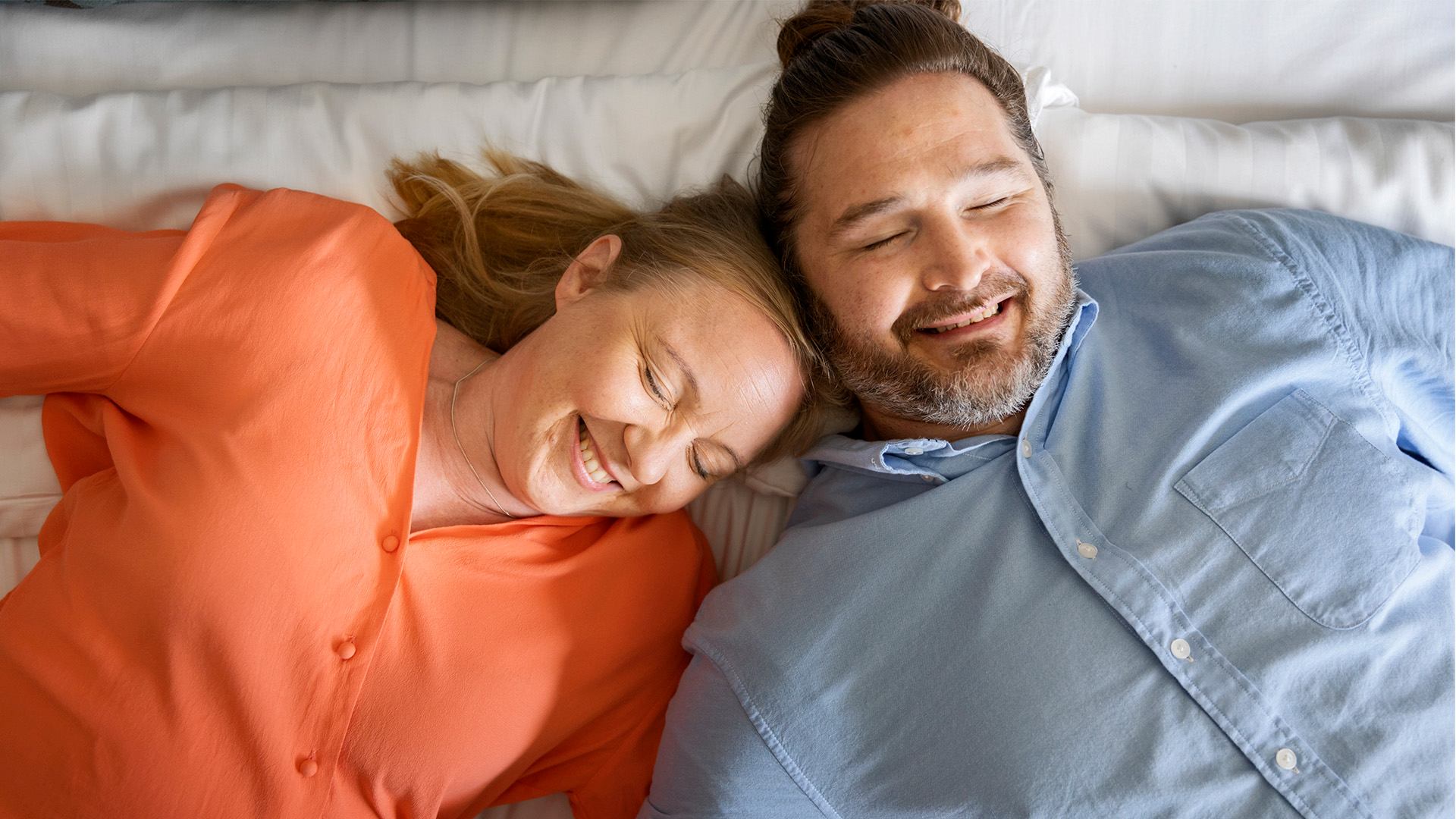 Mies ja nainen hotellin vuoteella pötköttelemässä