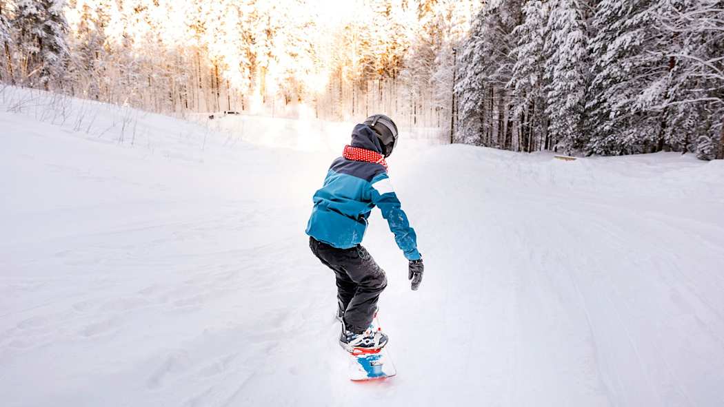 Lapsi lumilautailemassa