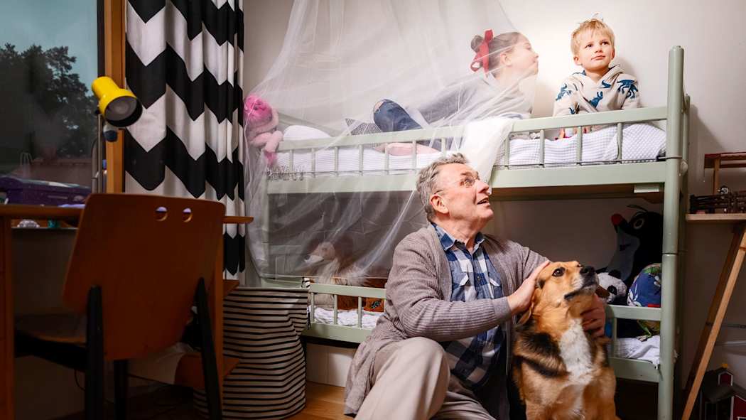 Isoisä, kaksi lasta ja koira lastenhuoneessa