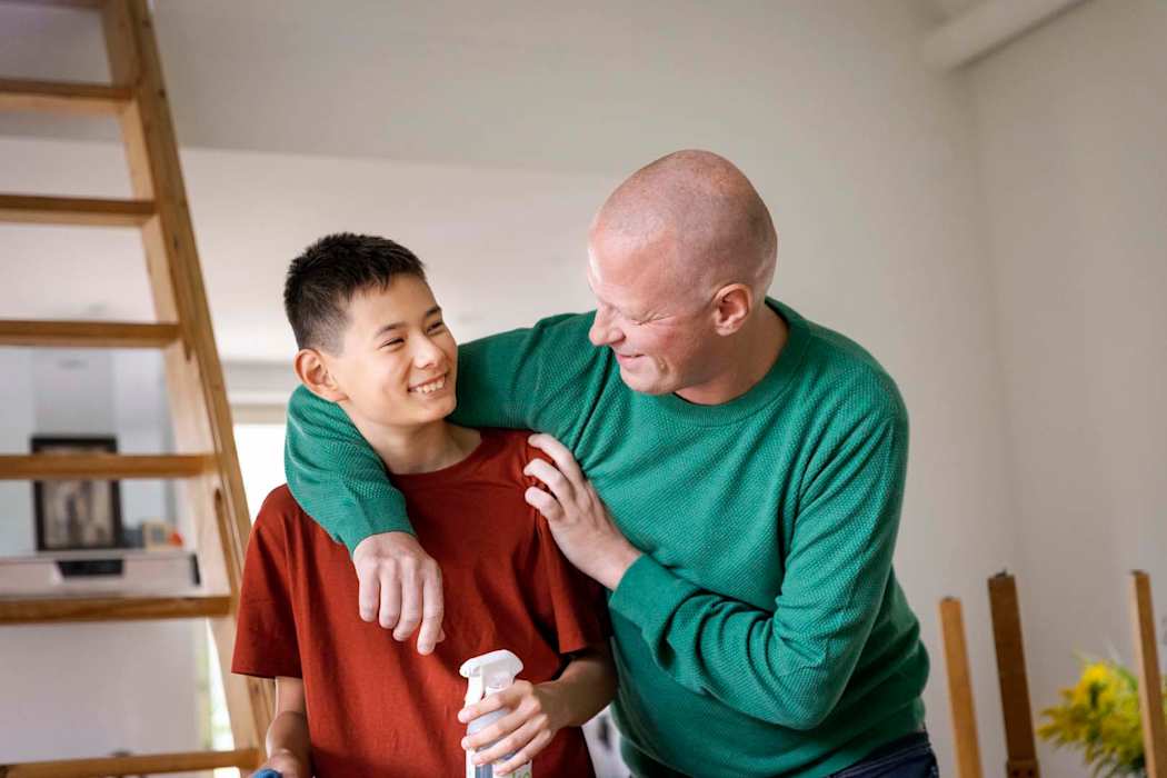 Isä ja poika halaavat hymyillen.