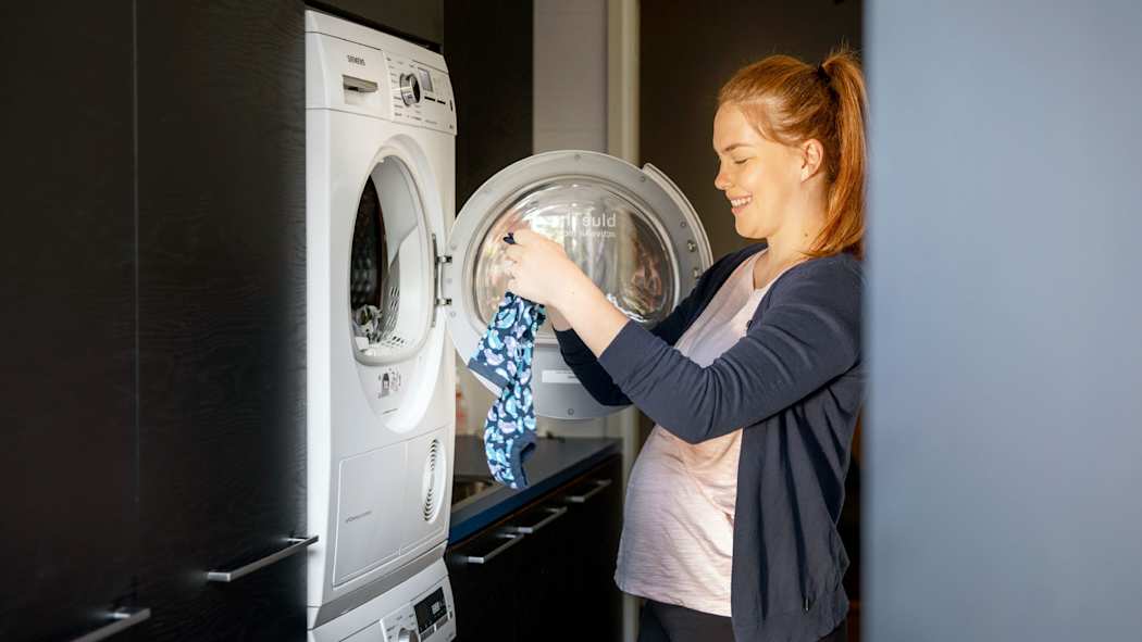 Nainen pesee vauvan pyykkiä