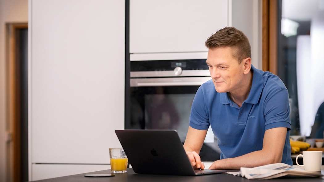 Mies hoitamassa vakuutusasioitaan tietokoneella
