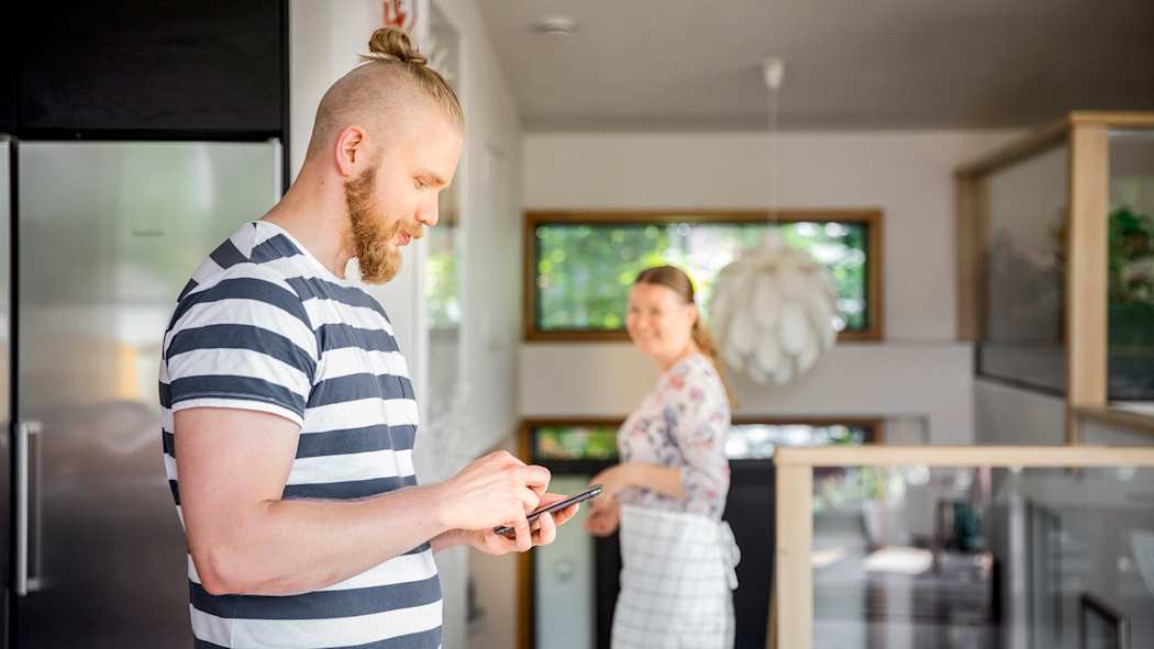 Mies puhelimellaan asioimassa TaskuTurvassa