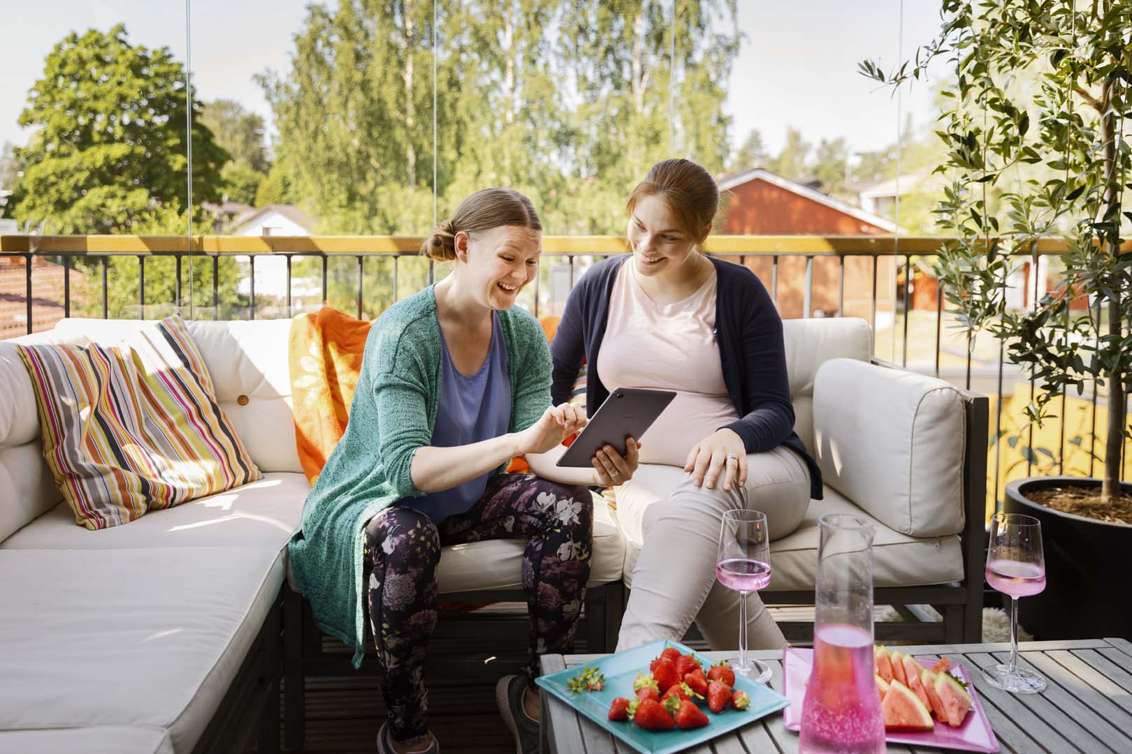 Naiset hymyilee ja katsoo tablettia
